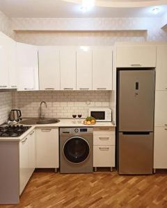 a kitchen with white cabinets and a dishwasher at Премиум квартира возле метро in Baku