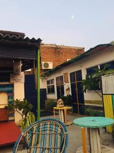 um pátio com uma mesa e cadeiras e um edifício em Chalo Eco Hostel em Jaipur