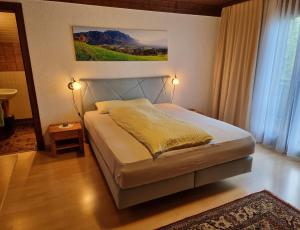 ein Schlafzimmer mit einem Bett und einem Wandgemälde in der Unterkunft Landgasthof Rössle ** Superior in Ruggell