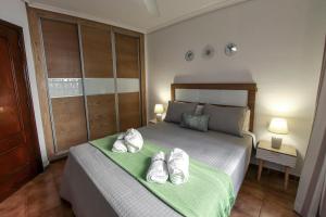 a bedroom with a bed with shoes on it at Paradise Gardens - Golf del Sur in San Miguel de Abona +28 photos