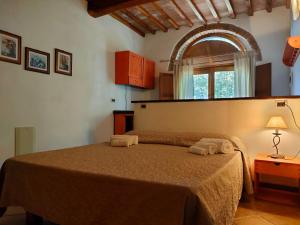 1 dormitorio con 1 cama con 2 toallas en Agriturismo Fattoria Lischeto, en Volterra