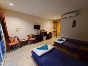 a room with two beds and a living room at Phutawan Resort in Chai Badan