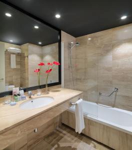 ein Badezimmer mit einem Waschbecken, einer Dusche und einer Badewanne in der Unterkunft H10 Itaca in Barcelona