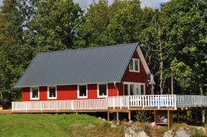 a red and white house with a gambrel roof at Relaxhouse in Håkantorp