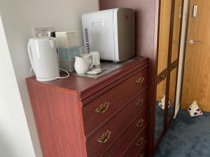 a wooden dresser with a appliance on top of it at Pagham Getaways in Pagham