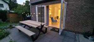 a picnic table and a bench on a patio at Bij Ons Naast in Nuenen