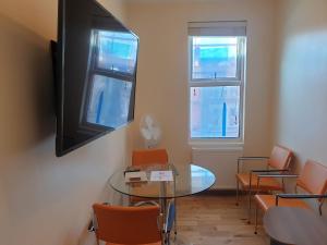 a meeting room with a glass table and chairs at London Luxury Spacious 2 Bedroom Apartment 4 mins from Ilford Stn. FREE parking in London
