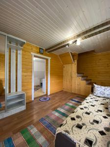 sypialnia z łóżkiem w pokoju z drewnianymi ścianami w obiekcie Котедж На Лузі w mieście Verkhne-Studënyy