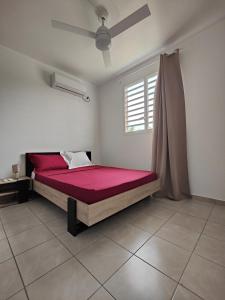 a bedroom with a red bed in a room at Rayon de soleil 1 chambre bas de villa in Sainte-Anne