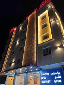 a tall building with a sign in front of it at Grand Orchid Hotel Apartment in Duqm