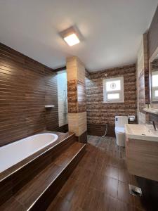 La salle de bains est pourvue d'une baignoire, de toilettes et d'un lavabo. dans l'établissement Grand Orchid Hotel Apartment, à Duqm