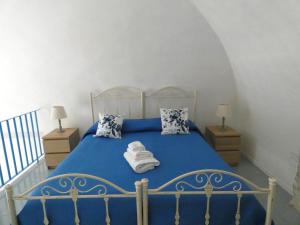 um quarto com uma cama azul com toalhas em House Sasanelli em Bari