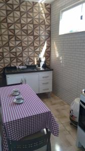 uma cozinha com uma mesa com uma toalha de mesa em hospedagem recanto do sábia 3 em Alto Caparaó