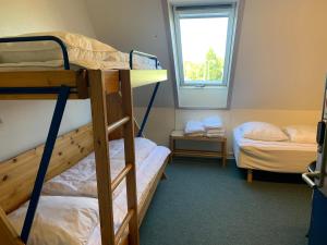 a bunk bed in a small room with a window at Danhostel Odense Kragsbjerggaard in Odense