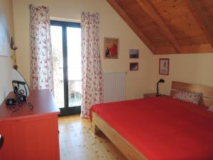 a bedroom with a red bed and a large window at Haus Jana in Hermagor