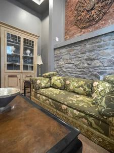 a living room with a couch and a stone wall at Redefined Alchemy LLC in Little Falls