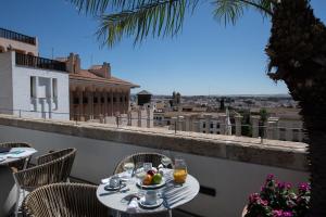 a table with a bowl of fruit on top of a balcony at Coliseum Boutique Apartments in Córdoba