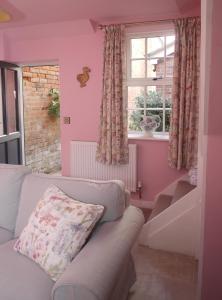 a living room with a couch and a window at The Gardener's Cottage in Leominster