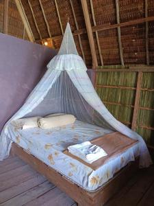 Una cama con una red en una habitación en Warahnus dive homestay, en Kri