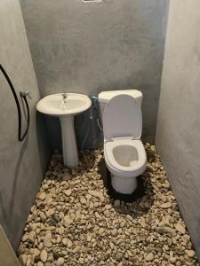 La salle de bains est pourvue de toilettes et d'un lavabo en pierre. dans l'établissement Warahnus dive homestay, à Kri
