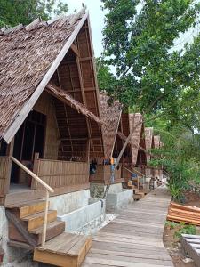 grupa domów z drewnianymi schodami i drzewami w obiekcie Warahnus dive homestay w mieście Kri