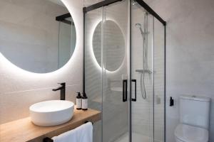 a bathroom with a sink and a glass shower at Coliseum Boutique Apartments in Córdoba
