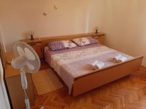 a bedroom with a bed and a fan at Apartmani Ino in Škrip