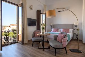 um quarto com uma cama, uma mesa e cadeiras em Coliseum Boutique Apartments em Córdoba