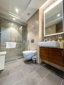 W łazience znajduje się toaleta, umywalka i lustro. w obiekcie STAY BY LATINEM Luxury Studio Holiday Home G2-2507 near Burj Khalifa w Dubaju