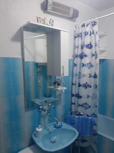 a blue bathroom with a sink and a mirror at Apartmani Ino in Škrip
