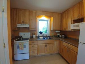 una cucina con armadi in legno e un piano cottura bianco con forno di Spacious country retreat close to town and nature, Sylvana Farm VT a Montpelier