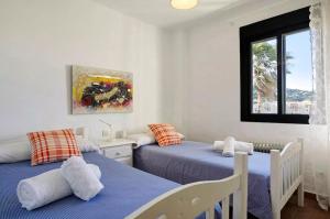 サアラ・デ・ロス・アトゥネスにあるSemifrontal con vistas a pie de playawifiのベッドルーム1室(ベッド2台、窓付)