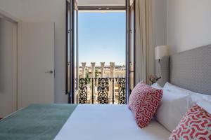 um quarto com uma cama e vista para uma varanda em Coliseum Boutique Apartments em Córdoba