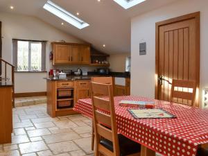 a kitchen with a table with a red table cloth at Isobels Cottage in Chapelton