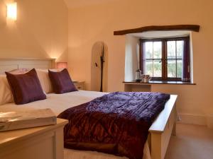 a bedroom with a large bed and a window at Isobels Cottage in Chapelton