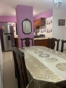 uma cozinha com uma mesa e uma cozinha com paredes roxas em Apartamento en BOCA CHICA, a 50 metros, playa boca chica em Boca Chica