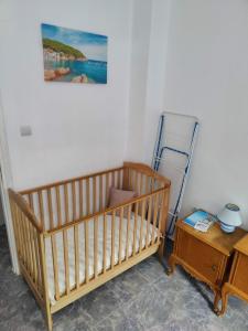a crib in a room with a table and a painting at Cosy apartment Acropolis Point 2 in Athens