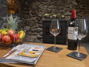 a table with two glasses of wine and a magazine at Pen Parc in Bryn-crug