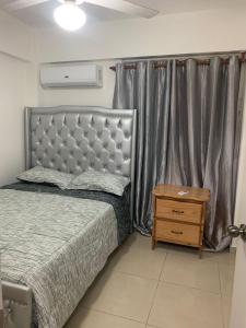 1 dormitorio con cama, mesita de noche de madera y cama sidx sidx sidx sidx en Apartamento en BOCA CHICA, a 50 metros, playa boca chica, en Boca Chica