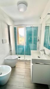 bagno con 2 lavandini, vasca e servizi igienici di Mare Azzurro a Cardedu