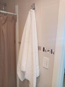 a white towel hanging on a rack in a bathroom at Bella Suit amoblada, sector exclusivo La Carolina. in Quito