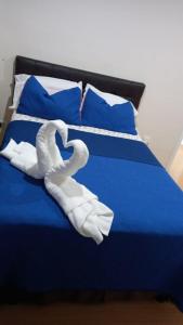 Una toalla blanca está puesta en una cama azul en Bella Suit amoblada, sector exclusivo La Carolina., en Quito