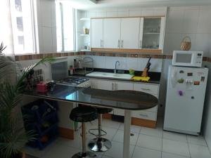 a kitchen with a white refrigerator and a counter top at Bella Suit amoblada, sector exclusivo La Carolina. in Quito +8 photos