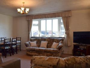 a living room with a couch and a table and a window at The Flat in Eaton