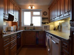 a large kitchen with wooden cabinets and a window at The Flat in Eaton