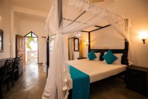 a bedroom with a bed with a canopy at International Beach Hotel & Restaurant in Hikkaduwa