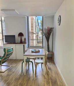 d'une salle à manger avec une table, des chaises et une fenêtre. dans l'établissement La Capucine, à Montauban