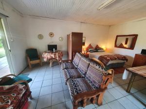 um quarto com uma cama, um sofá e uma mesa em Kaapsche Draai em Kaapsehoop