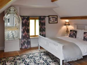 a bedroom with a white bed and a window at The Old Cider Mill in Llanstephan