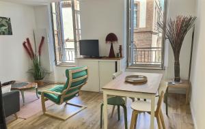 a living room with a table and chairs and a dining room at La Capucine in Montauban